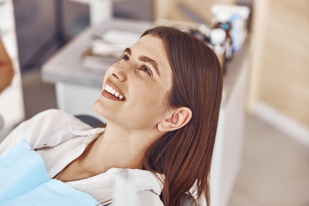 woman smiling in the dental chair - Littleton dentist